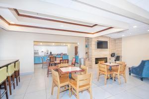 une salle à manger avec des tables, des chaises et une cheminée dans l'établissement Country Inn & Suites by Radisson, Midway - Tallahassee West, à Midway