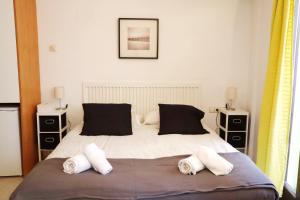 a bedroom with a large bed with two pillows at Girona La Lleona in Girona