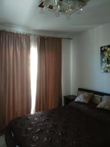 een slaapkamer met een bed en een raam met gordijnen bij Casa Montesol in Calpe