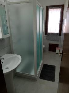 y baño con ducha acristalada y lavamanos. en Appartamento 89, en Torre dei Corsari