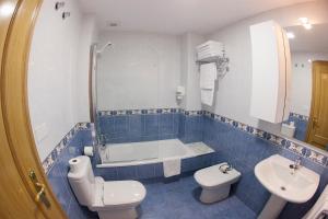 W łazience znajduje się toaleta, wanna i umywalka. w obiekcie Laros Pios Alojamiento w mieście Villalba