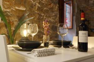 赫羅納的住宿－Girona Catedral，一张桌子,上面放着一瓶葡萄酒和两杯酒