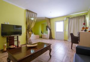 a living room with a flat screen tv and a table at Paradice Hotel Luxury Suites-Near zorbas Beach-FREE Breakfast in Stavros