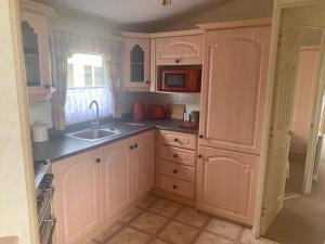 a kitchen with white cabinets and a sink and a window at Lyndhurst Corner 72 in Dunoon
