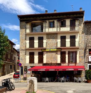 ein Gebäude mit einer roten Markise davor in der Unterkunft Hostal Rural Sositana in Castejón de Sos