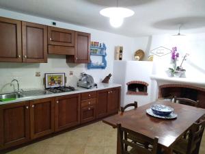 a kitchen with wooden cabinets and a wooden table at Locanda B&B Dandana in Orgosolo