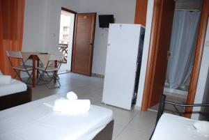 a living room with a white refrigerator and a table at VILA NIKOLETA in Ierissos