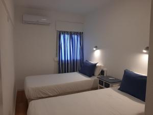 a hotel room with two beds and a window at Quarteira SeaSide in Quarteira