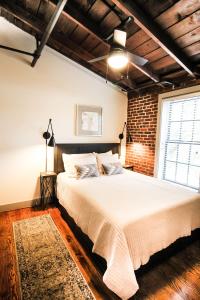 a bedroom with a bed and a brick wall at The Lofts at Downtown Salem in Salem