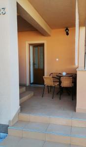a patio with a table and chairs in a house at Apartments Valiža 2 in Senj
