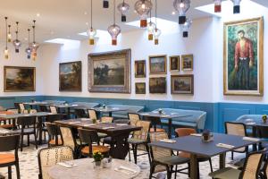 comedor con mesas, sillas y pinturas en las paredes en Hotel Indigo Verona - Grand Hotel Des Arts, an IHG Hotel en Verona