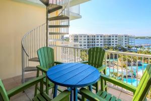 a balcony with a blue table and two chairs at Destin West Resort in Fort Walton Beach