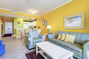 a living room with two couches and a table at Destin West Resort in Fort Walton Beach