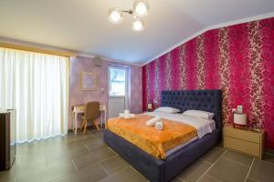 a bedroom with a large bed with pink walls at Paradice Hotel Luxury Suites-Near zorbas Beach-FREE Breakfast in Stavros