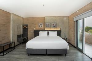 מיטה או מיטות בחדר ב-Hotel Quinta Norte Chipichape