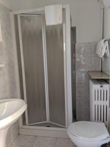 a white toilet sitting next to a shower in a bathroom at Hotel Dorico in Ancona