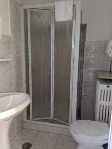 a white toilet sitting next to a bath tub in a bathroom at Hotel Dorico in Ancona