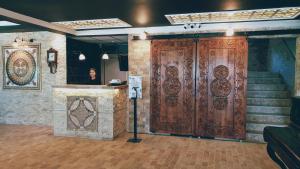 a woman standing in front of a large wooden door at Royal Park Hotel Corlu in Tekirdağ