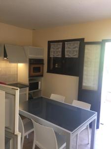 a kitchen with a blue table and white chairs at gîtes de corse in Ventiseri