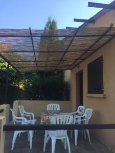 a patio with a table and chairs under a pergola at gîtes de corse in Ventiseri