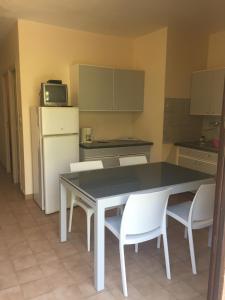 a kitchen with a black table and white chairs at gîtes de corse in Ventiseri