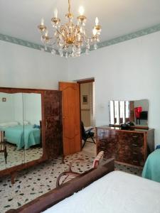 ジョイオーザ・マレーアにあるCasa Vacanze Gioiosa Mareaのベッドルーム1室(鏡、ベッド1台、シャンデリア付)