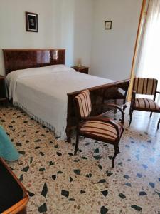 ジョイオーザ・マレーアにあるCasa Vacanze Gioiosa Mareaのベッドルーム1室(大型ベッド1台、椅子2脚付)