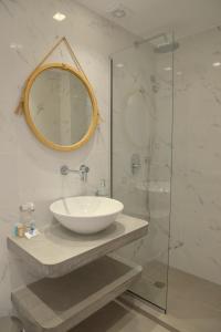 a bathroom with a sink and a glass shower at Giannis Hotel Apartments in Adamantas