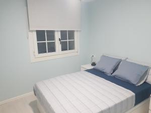 een bed in een witte kamer met een raam bij Barcia 3 in Pontevedra