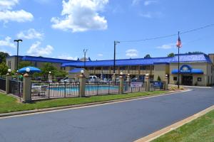 a building with a fence in front of a street at Rodeway Inn High Point - Archdale in Archdale