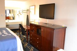 a hotel room with a dresser with a television on it at Rodeway Inn High Point - Archdale in Archdale