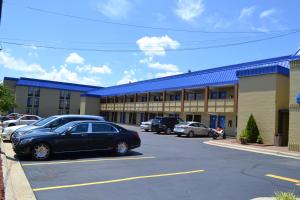 a black car parked in a parking lot in front of a building at Rodeway Inn High Point - Archdale in Archdale