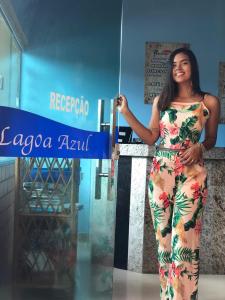 uma mulher num vestido segurando um guarda-chuva em Pousada Recanto Lagoa Azul em Baixio