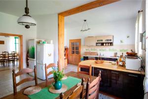 a kitchen with a table and a white refrigerator at Gajówka in Węgorzewo