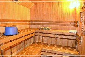 a wooden sauna with a blue tub in it at Sodyba Basapėdė in Bijutiškis