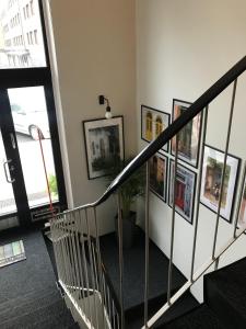 a hallway with a spiral staircase with pictures on the wall at Tapulitalo Guesthouse in Turku