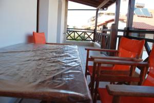 een houten tafel en stoelen op een balkon bij VILA NIKOLETA in Ierissos