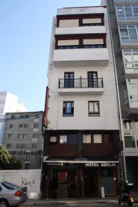 a tall white building with a hotel attic at Hostal Adelia in A Coruña