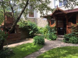 ein Haus mit einem Garten mit grünem Gras in der Unterkunft Usadba Bilya Richky in Skole