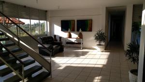 a living room with a staircase and a chair at Hotel Nautico in Três Marias