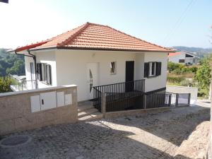 Biały dom z bramą i balkonem w obiekcie Apartamento Amarante - Vista São Gonçalo w mieście Amarante