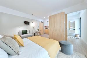 a bedroom with a large bed and a living room at Art Home Apartments in Aveiro