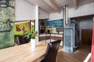 a kitchen with a wooden table and a fireplace at White Tower of Love in Bressanone