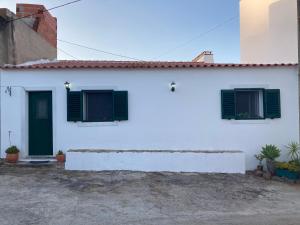 a white house with green shutters on it at Casa do Correio in Odeleite