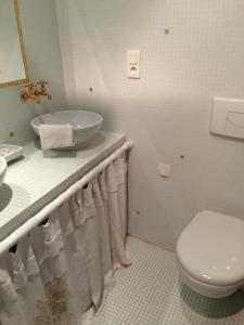 朗巴勒的住宿－CHAMBRE ROMANTIQUE CHEZ L'HABITANT à LAMBALLE，白色的浴室设有水槽和卫生间。
