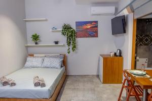 a bedroom with a bed and a table and a desk at Old Town Boutique Apart Studio's - Rethymno in Rethymno Town