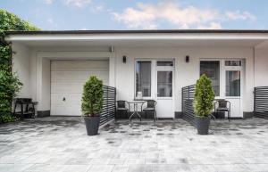 a white house with two chairs and a garage at Albatros PRZY PLAŻY in Władysławowo