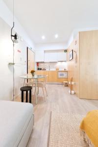 a living room with a table and a kitchen at Art Home Apartments in Aveiro