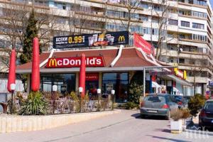 a mcdonalds restaurant with cars parked in front of it at Apartament Sunny, Варна- център in Varna City