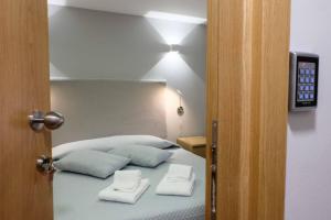 a bedroom with a bed with two towels on it at MAGNIFIKSTYLE - Alojamento Local 1 in Guarda